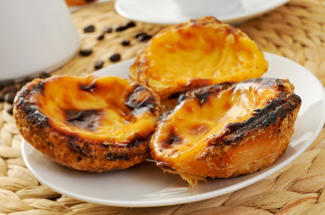 a plate with pasteis de nata, typical Portuguese egg tart pastries on a set table